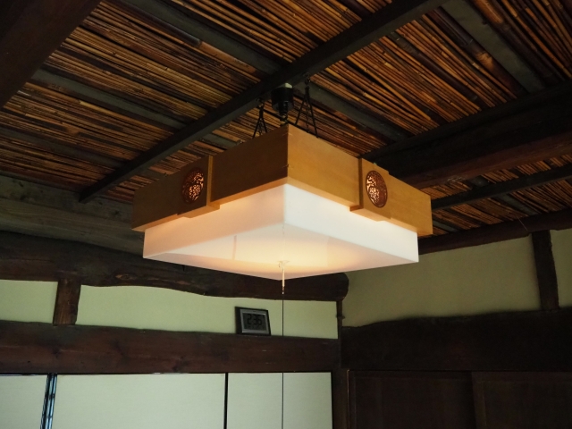 煤竹の天井から伸びる古いタイプの電灯